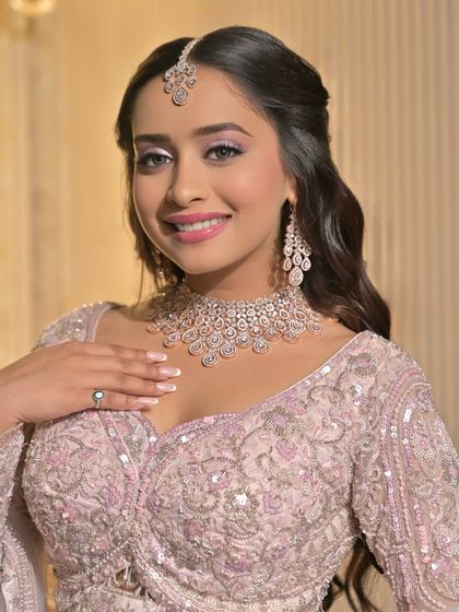 A joyful and radiant look. The soft makeup allows the bride's natural happiness to shine through, complemented by the delicate pastel outfit and diamond jewelry.