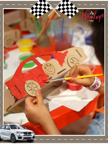 Hands-on creativity is a core part of my events. This close-up shot shows a child carefully painting a wooden model car during our Mini Racers themed party, a perfect take-home souvenir.