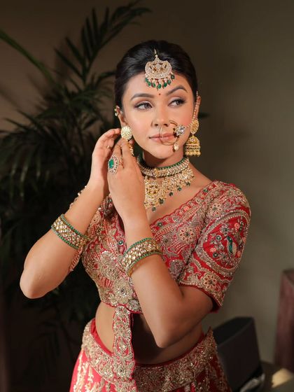 A close-up shot of a guest getting her earrings on. The glittery eyes and radiant skin are the focus of this beautiful makeup look.