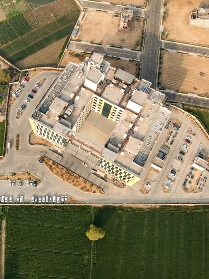 An aerial view of the 500-bed Pragma Medical Institute. Our design utilizes a solar-passive 'core-envelope' strategy to optimize natural light and reduce energy dependence, aligning with LEED Gold standards for sustainable infrastructure.