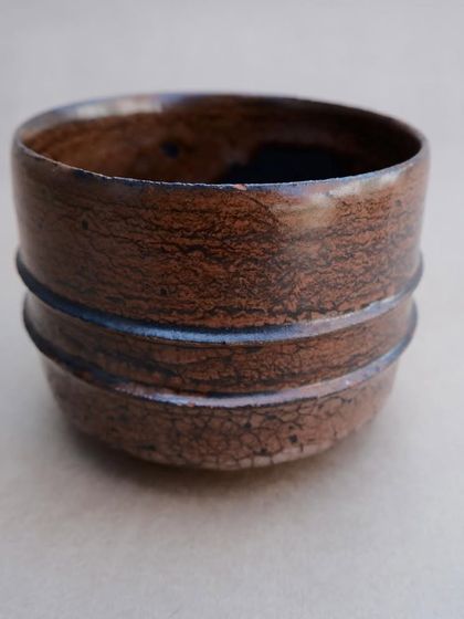 A close-up of a Raku-fired teabowl. The crackle pattern in the glaze, known as 'crazing', is a characteristic feature of this technique.