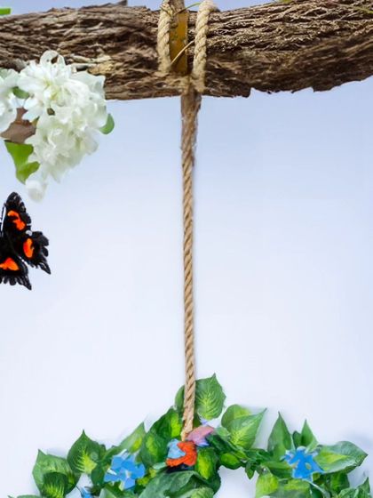 A detail shot of a nature-themed studio prop. This leafy wreath with butterflies is used to create an enchanting backdrop for newborn photos.