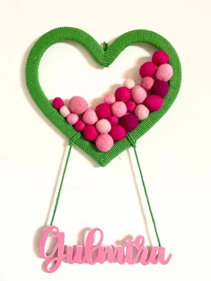 A heart-shaped nameplate for 'Gulmitra', filled with shades of pink pom-poms. This is a great example of how I can customize both the shape and color palette to create the perfect piece.