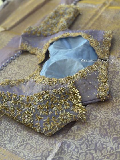 A lavender blouse with a sheer back and delicate floral embroidery.