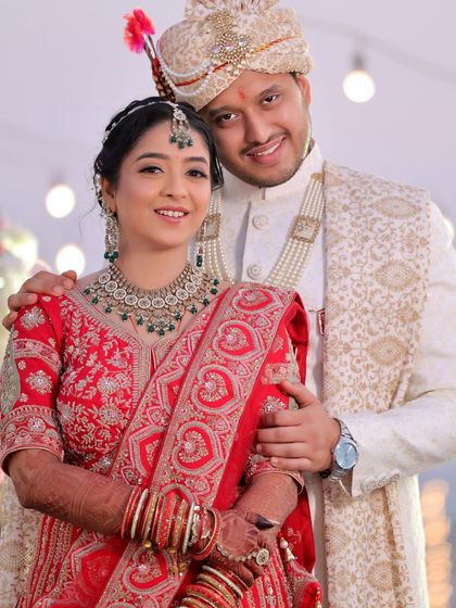 A traditional wedding portrait of the couple looking at the camera. This photo is perfect for family albums, capturing them in their full wedding attire.
