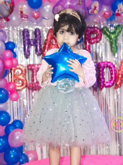 The birthday girl posing with her star balloon in front of a colorful backdrop. These portraits highlight the fun theme and the child's party dress.