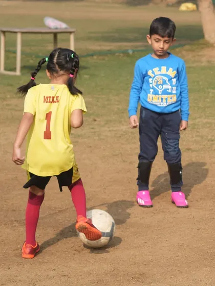 A young girl with pigtails controls the ball. Building strong fundamentals from the first dribble is key to a lifelong love for the game.