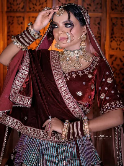 A three-quarter portrait of the bride, her pose highlighting the rich texture and embroidery of the velvet outfit.