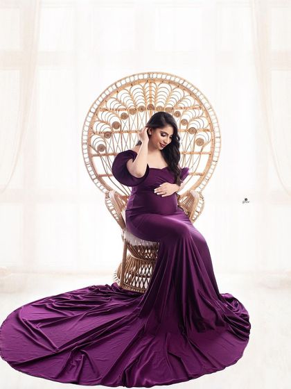 A beautiful portrait featuring the popular peacock chair. The client is seated in a regal purple gown, creating a look of sophisticated boho elegance.