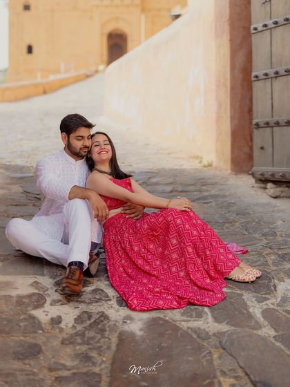 A relaxed and happy portrait of the couple sitting on the ancient cobblestone paths of Jaipur.