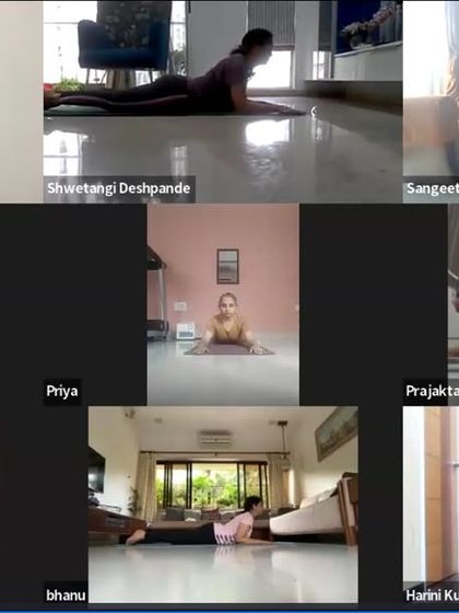 Students practicing Bhujangasana (Cobra Pose) in sync during an online morning class. This gentle backbend is a great way to energize the spine and open the chest at the start of the day.