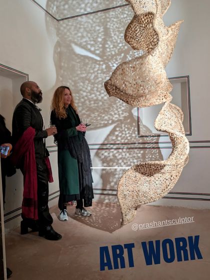 Visitors contemplating the spiral sculpture at The Sculpture Park. This image shows how the artwork engages its audience, inviting them to look closer and discuss its meaning and material.