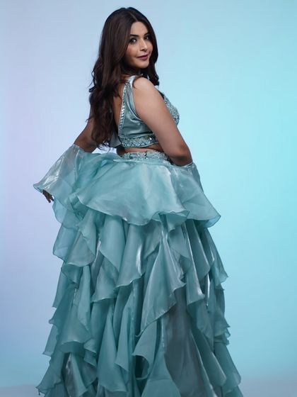 Feel like a dream in this light blue ruffled lehenga. The tiered skirt adds so much drama and movement, making it a fun choice for a cocktail night or reception party.