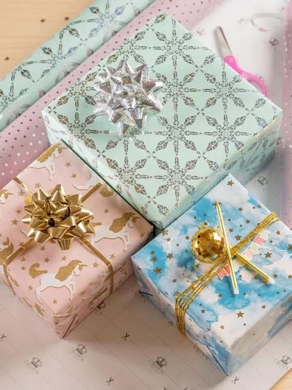A playful and colorful flat lay of gifts wrapped in pastel-colored paper with unicorn and star patterns. This shot is perfect for children's birthday parties or baby showers.