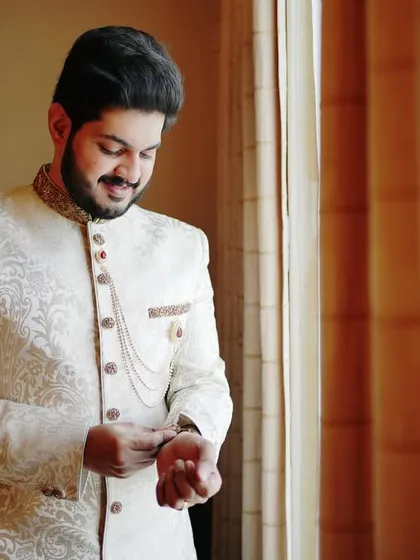 A close-up of the groom adjusting his cuff. We focus on these small, final touches that signify the importance of the moment.
