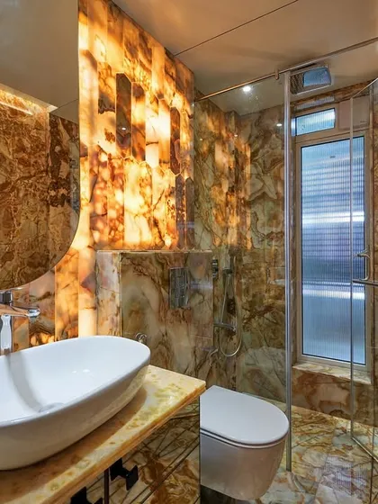 We transformed this space into a breathtaking powder room using floor-to-ceiling backlit Onyx marble. This technique turns the entire room into a statement piece, creating a warm, ambient glow that highlights the natural, dramatic patterns of the stone.