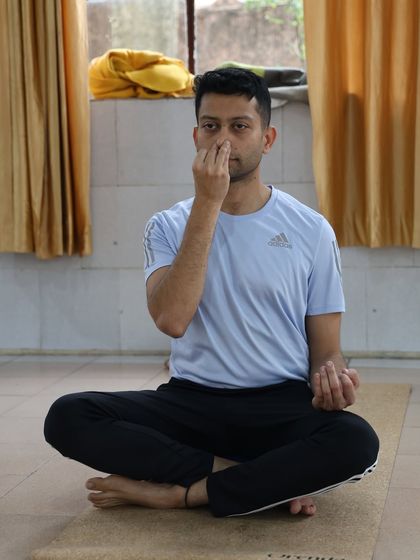 A young man practices pranayama, focusing on his breath. These techniques are beneficial for people of all ages to manage stress and improve mental focus.