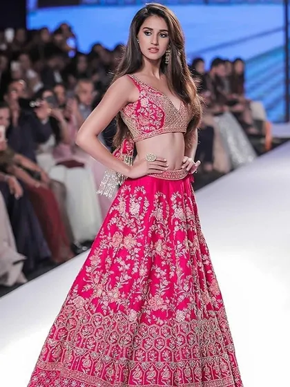 A vibrant pink lehenga with detailed floral embroidery, perfect for a sangeet or wedding reception. We can replicate your favorite designer styles with high-quality fabrics and craftsmanship.