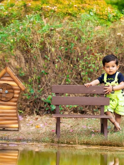 This little explorer is enjoying his outdoor session. I use miniature props like this bench and birdhouse to add a whimsical touch to my kids' photography in natural settings.