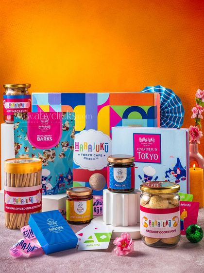 A vertical shot of a large Harajuku Tokyo Cafe gift hamper, showcasing the full range of products against a bright orange background.