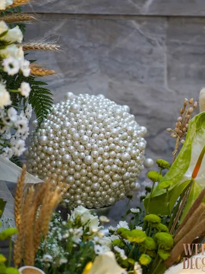 Another angle of the pearl sphere accent, nestled among fresh greenery and anthuriums. The contrast between the smooth pearls and the natural flowers is visually striking.