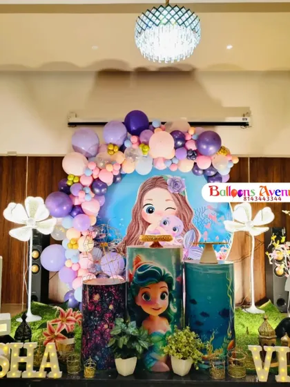 A centered shot of the mermaid party stage, showing the themed pedestals and character cutouts.