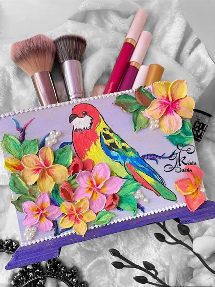 Art can be functional too. This multipurpose utility stand, featuring a brightly painted macaw amidst tropical flowers, is perfect for holding makeup brushes, cutlery, or pens. It’s a cheerful and practical piece to brighten your desk or vanity.