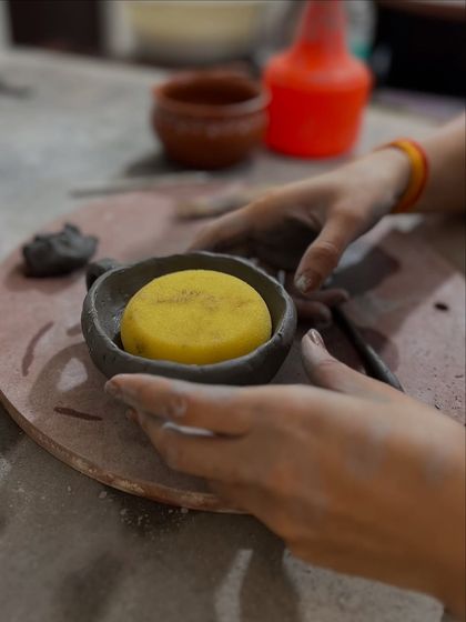 Using a sponge to smooth the surface of a freshly made bowl. Every step in the hand-building process is a tactile and meditative experience.