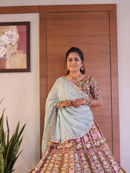 A full-length view of this soft and elegant look. The makeup perfectly complements her beautiful, earthy-toned lehenga.