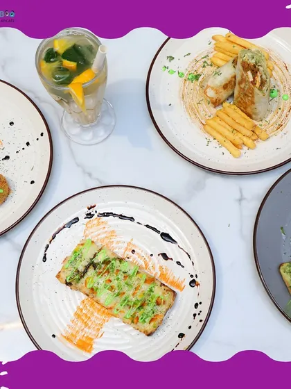 A top-down view of a table spread with some of our most popular appetizers. You can see our shawarma wrap, cheesy garlic bread, avocado bruschetta, and another tasty bite, all ready to be shared.