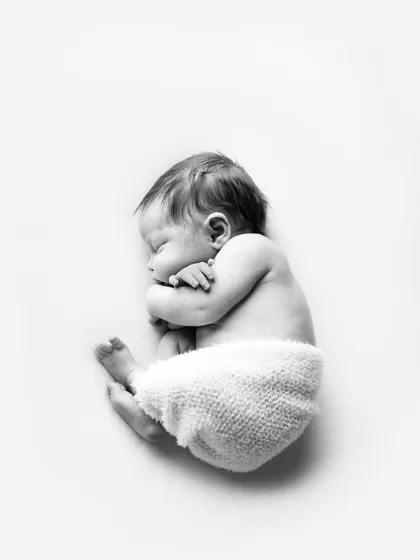 The delicate art of newborn photography. This classic black and white portrait highlights the peaceful innocence of a new baby. As an Ana Brandt certified photographer, I prioritize your baby's safety and comfort above all else.