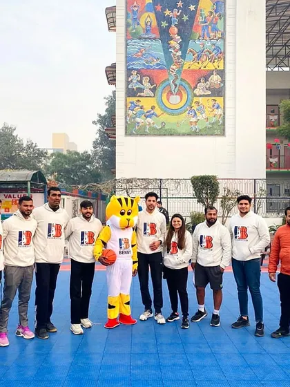 Our unified coaching team, including our mascot! We believe in leading by example, and our teamwork as coaches is reflected in the performance of our players on the court.