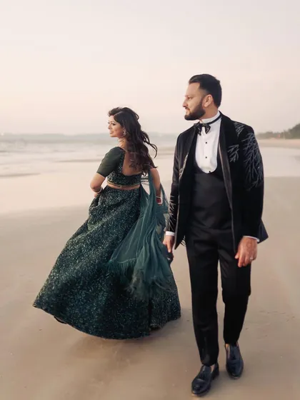 A walk on the beach at dusk, with the bride's lehenga catching the sea breeze. This is a portrait in motion, capturing the feeling of moving forward together. It’s a perfect blend of elegance and the relaxed vibe of a destination wedding.