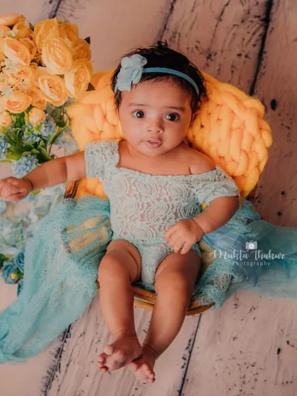 A full-length shot showing off her adorable lace outfit and the beautiful textures of the setup. These sitter sessions are perfect for 3-month-old babies.
