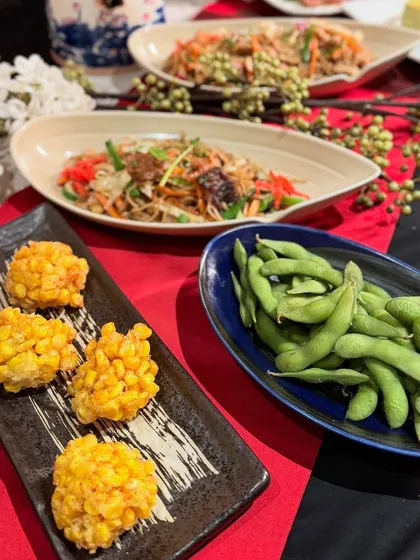 A closer look at our corn fritters and edamame, simple yet flavorful dishes that are great for any gathering. They are served alongside two types of Japanese salads.