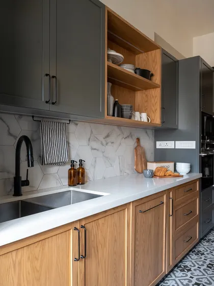 A wider view of the wood and grey kitchen, showing the flow from the sink area to the main counter. The consistent use of materials and the thoughtful layout create a space that is both aesthetically pleasing and highly practical for daily use.