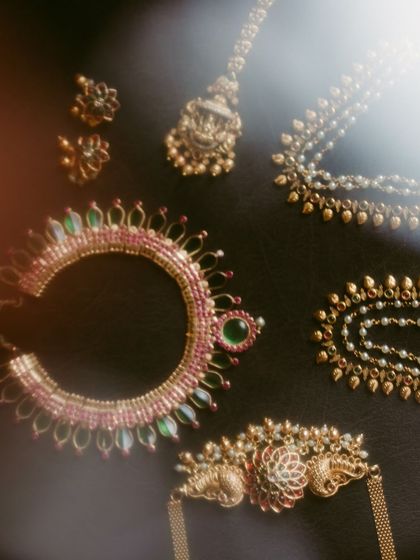 An artistic flat-lay of the bride's traditional temple jewelry. We use soft light to highlight the beautiful craftsmanship of each piece.