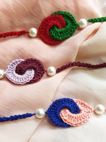 A collection of our 'pyaar ka bandhan' rakhis, featuring two intertwined crochet spirals in complementary colors. These designs symbolize the connected and loving relationship between siblings.