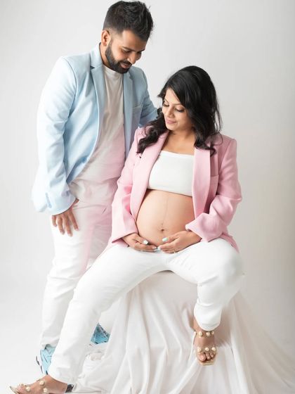 Dressed in stylish matching blazers, this couple shares a loving gaze. This shot combines modern fashion with the timeless emotion of expecting a child.