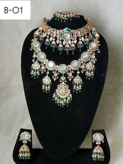 This is my rental set B-01, a gorgeous layered design with large polki stones and green meenakari details. It includes a choker, a mid-length necklace, and matching jhumka earrings for a complete look.