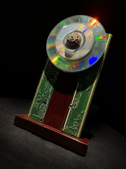 A close-up of one of my custom awards, crafted from a recycled CD and a circuit board. These pieces can be customized with company branding, offering a unique way to align sustainability goals with corporate recognition.