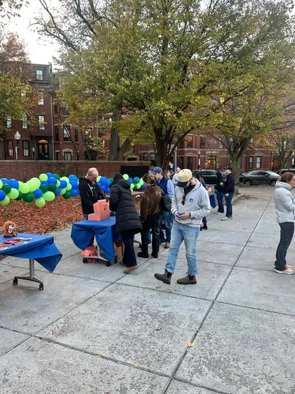 Another view of the park event, with people gathered around tables and balloons. Being in the middle of the action allows me to capture the true feeling of a community celebration.