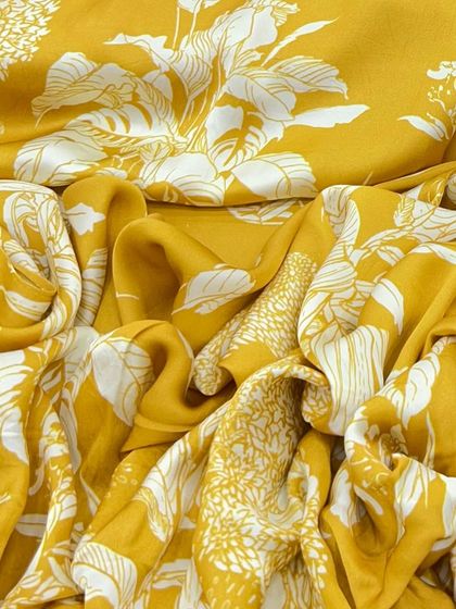 Create magic with our fluid and vibrant modal satin. This bold yellow and white floral print is perfect for a statement dress, anarkali, or a chic co-ord set.