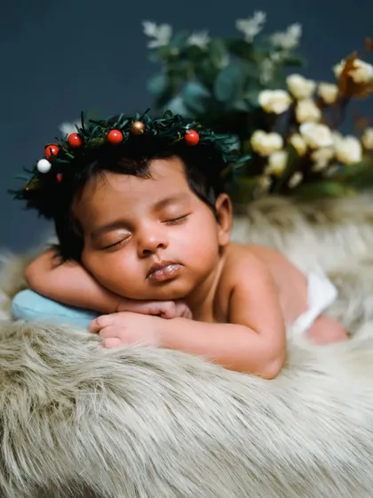 A Christmas-themed newborn shoot with a tiny wreath. This is a wonderful way to celebrate your baby's first holiday season.
