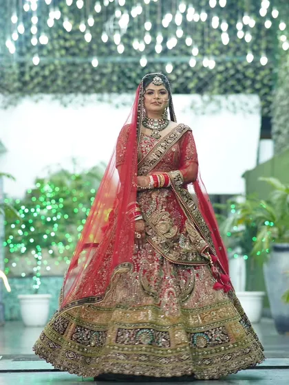 A full-length shot of the bride is a must. This photo showcases her entire wedding attire, from the detailed lehenga to the flowing dupatta, set against a beautifully lit backdrop.