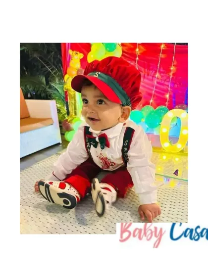 This little boy is ready for his Christmas-themed birthday party in our custom red and white outfit with suspenders and a matching cap. The details make it festive, while the design keeps it comfortable for play.
