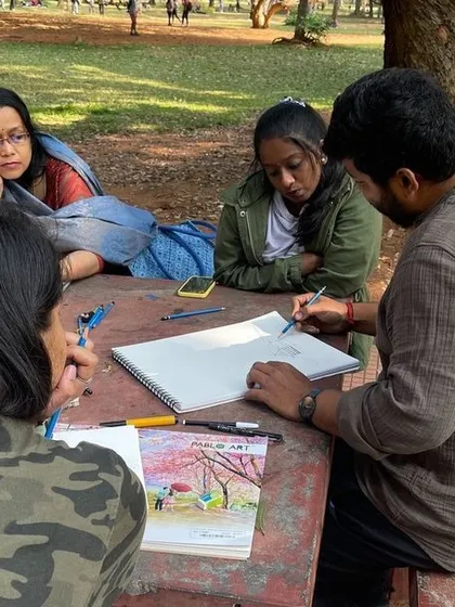 An instructor gives feedback during a fun plein air sketching session, helping students capture the true effects of light on nature's colors.