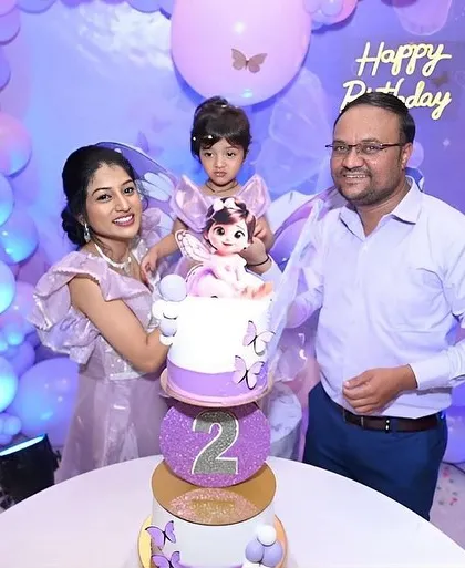 A happy family celebrating their daughter Saiyami's second birthday with our butterfly-themed cake.