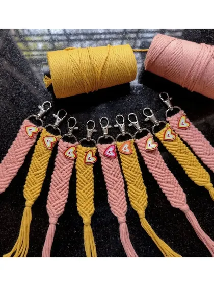 We also make macrame bag charms, perfect for gifting. These pink and yellow ones feature a beautiful woven pattern and a small heart charm for a little extra love.