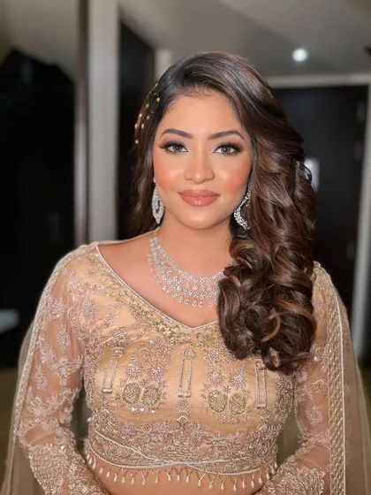 Krisha rocking her sangeet look in a beautiful gold lehenga. The makeup is glamorous with a focus on bronzed, glowing skin and a smokey eye.